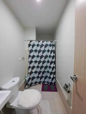 a bathroom with a toilet and a shower curtain at Apartment Condo Unit in Rizal in Manila