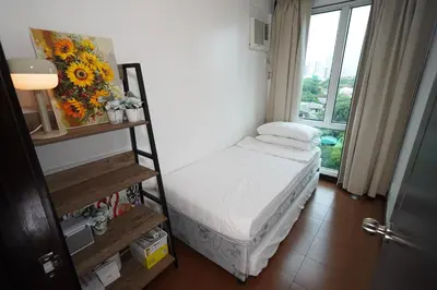 a small room with a bed and a window at Hayahay Rentals in Manila