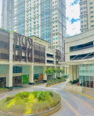 a large building in a city with tall buildings at Hayahay Rentals in Manila