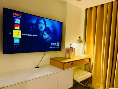 a flat screen tv hanging on a wall at Masies Beach View Suite at Azure Urban Resort Residences in Manila