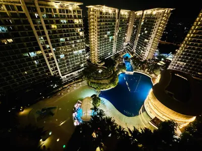 an aerial view of a pool at night with tall buildings at Masies Beach View Suite at Azure Urban Resort Residences in Manila