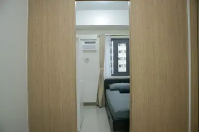 a door to a room with a bed and a mirror at Quiet Oasis in Bloom Residences in Manila
