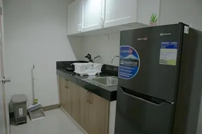 a small kitchen with a refrigerator and a sink at Quiet Oasis in Bloom Residences in Manila