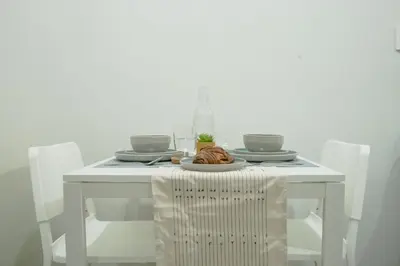 a white table with a plate of food on it at Quiet Oasis in Bloom Residences in Manila