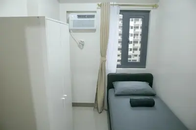 a small room with a couch and a window at Quiet Oasis in Bloom Residences in Manila