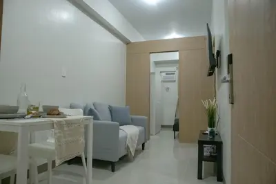 a living room with a couch and a table at Quiet Oasis in Bloom Residences in Manila