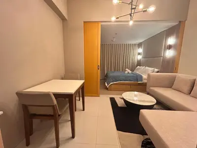 a living room with a couch and a table at One Uptown Residences BGC in Manila