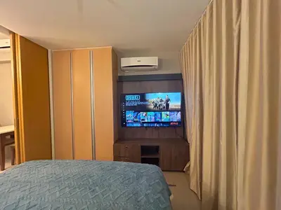 a bedroom with a flat screen tv and a bed at One Uptown Residences BGC in Manila