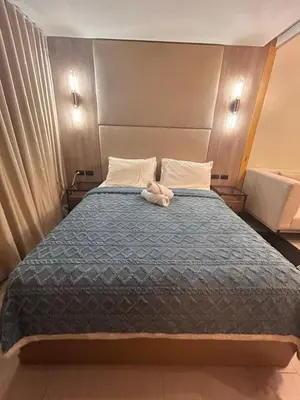 a bed with a stuffed animal laying on top of it at One Uptown Residences BGC in Manila