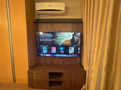 a flat screen tv in a room with a curtain at One Uptown Residences BGC in Manila
