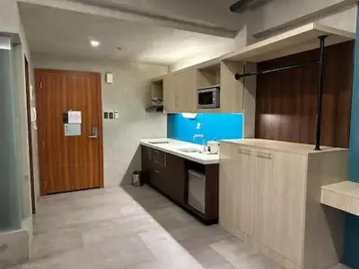 a small kitchen with a sink and a wooden door at Cozy Spacious Pet Friendly Unit with Netflix Pool Gym in Manila