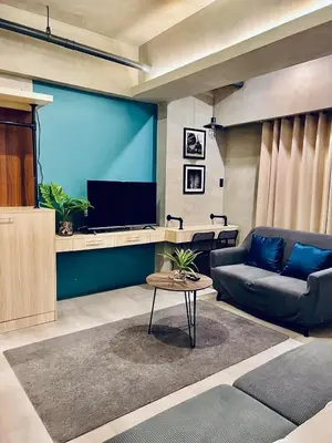 a living room with a couch and a flat screen tv at Cozy Spacious Pet Friendly Unit with Netflix Pool Gym in Manila