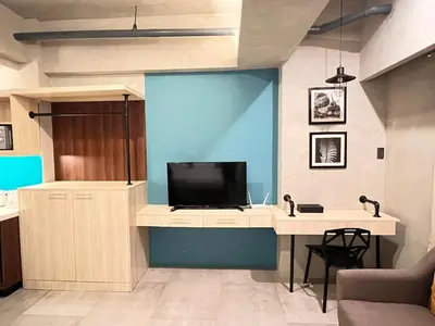 a living room with a tv and a desk at Cozy Spacious Pet Friendly Unit with Netflix Pool Gym in Manila