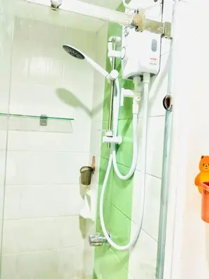 a shower in a bathroom with a shower at Belthena Suite in Las Piñas Near Airport in Manila