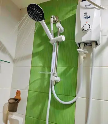 a shower in a bathroom with a green wall at Belthena Suite in Las Piñas Near Airport in Manila