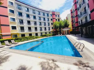 a swimming pool in front of a building at Belthena Suite in Las Piñas Near Airport in Manila