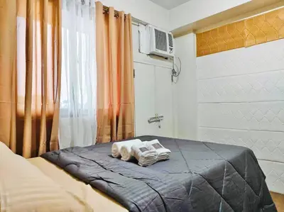 a bedroom with a bed with towels on it at Belthena Suite in Las Piñas Near Airport in Manila