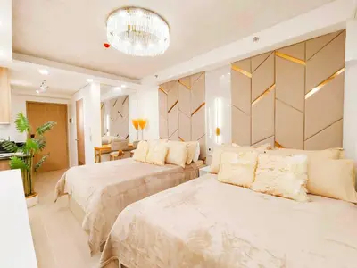 a bedroom with two beds and a chandelier at Premium Condotel Close To MOA in Manila