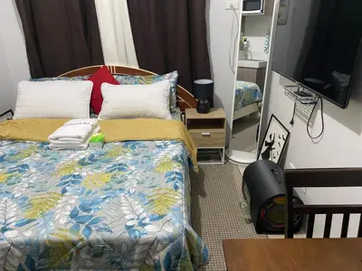 a bedroom with a bed and a television in it at Pierrecondotel in Manila