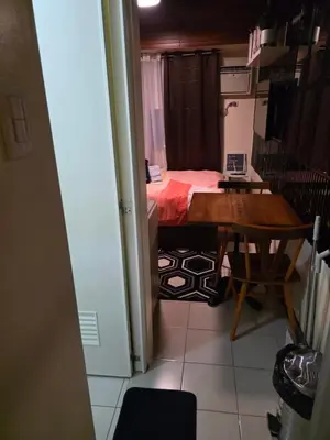 a small room with a table and a bed at Nicecondote in Manila
