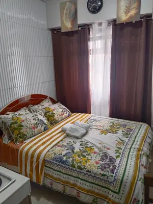 a bedroom with a bed with a quilt on it at Nicecondote in Manila