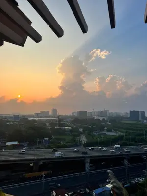a sunset over a highway with cars on the freeway at 1 Bedroom Penthouse Condo Near Airport NAIA in Manila