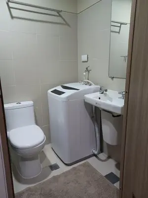 a white bathroom with a toilet and a sink at Casa R and R Cozy Staycation at S Residences in Manila
