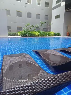 a large swimming pool with blue water in a building at Casa R and R Cozy Staycation at S Residences in Manila