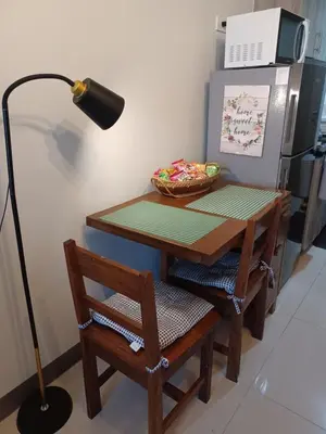 a table with a lamp and a table with chairs and a tableablish at Casa R and R Cozy Staycation at S Residences in Manila