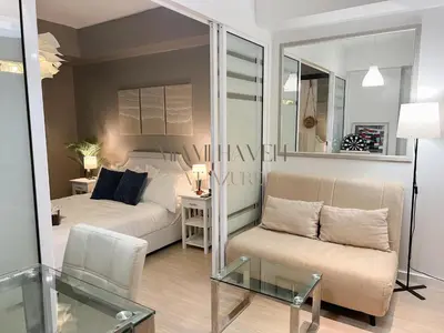 a living room with a bed and a couch at Miami Haven at Azure in Manila