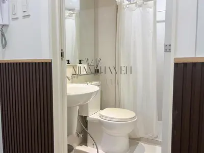 a white bathroom with a toilet and a sink at Miami Haven at Azure in Manila