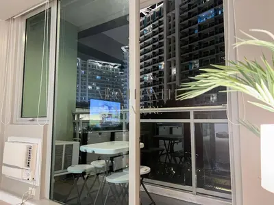 a room with a window with a table and chairs at Miami Haven at Azure in Manila