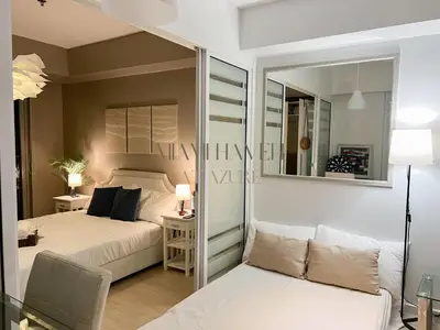 a bedroom with a bed and a couch at Miami Haven at Azure in Manila