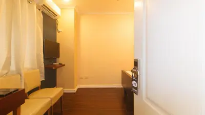 a small room with a couch and a television at RedDoorz at Emperor Manila Boutique Hotel in Manila