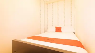 a small bedroom with a bed with a box on it at RedDoorz at Emperor Manila Boutique Hotel in Manila
