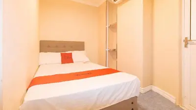 a bedroom with a bed with an orange pillow on it at RedDoorz at Emperor Manila Boutique Hotel in Manila