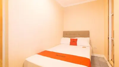 a small bedroom with a bed with a red box on it at RedDoorz at Emperor Manila Boutique Hotel in Manila