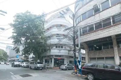 a large white building with cars parked in front of it at RedDoorz at Emperor Manila Boutique Hotel in Manila