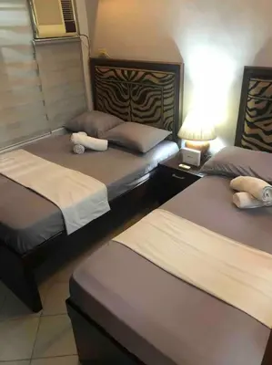 a bedroom with two beds and a lamp on a table at COMFY 1-BR Condo near SLEC, US Embassy, Malls,Park in Manila
