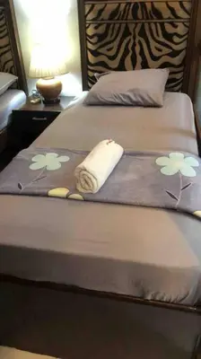 a bed with a blanket with flowers on it at COMFY 1-BR Condo near SLEC, US Embassy, Malls,Park in Manila
