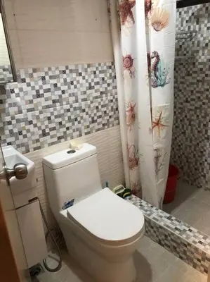 a bathroom with a toilet and a shower curtain at COMFY 1-BR Condo near SLEC, US Embassy, Malls,Park in Manila