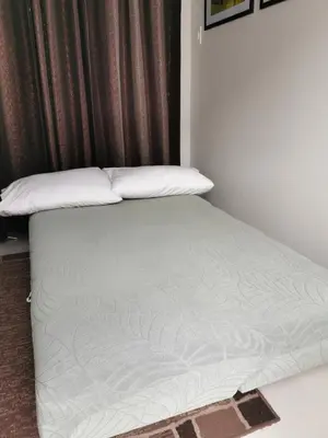 a bed with white sheets and pillows in a room at Mall of Asia Pasay Shore 3 Residence in Manila