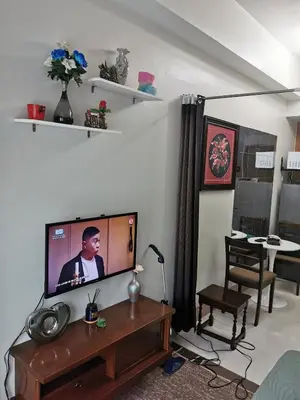 a living room with a flat screen tv on a table at Mall of Asia Pasay Shore 3 Residence in Manila