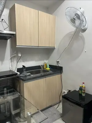a kitchen with a sink and a desk with a fan at POEA Mega Mall WiFi Netflix in Manila