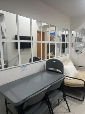 a table and a chair in a room with a mirror at POEA Mega Mall WiFi Netflix in Manila