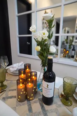 a bottle of wine and candles on a table with flowers at San Lorenzo Place Mall & Residences Tower 3 by Magallanes MRT station Makati in Manila