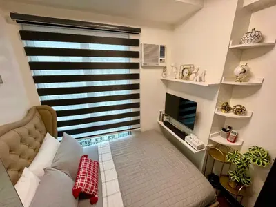 a bedroom with a bed and a large window at San Lorenzo Place Mall & Residences Tower 3 by Magallanes MRT station Makati in Manila