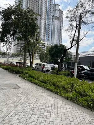 a sidewalk in a city with tall buildings at San Lorenzo Place Mall & Residences Tower 3 by Magallanes MRT station Makati in Manila