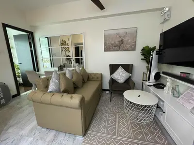 a living room with a couch and a tv at San Lorenzo Place Mall & Residences Tower 3 by Magallanes MRT station Makati in Manila