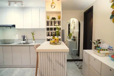 a kitchen with white cabinets and a counter with drinks on it at San Lorenzo Place Mall & Residences Tower 3 by Magallanes MRT station Makati in Manila